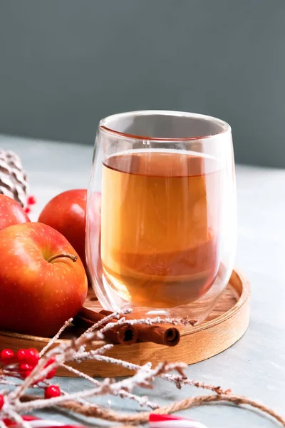 Concepto estacional y festivo. Invierno té caliente en un vaso con manzanas y especias sobre un fondo de madera. Enfoque selectivo, vista superior — Foto de Stock