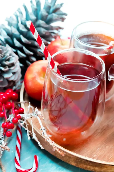 Concepto estacional y festivo. Invierno té caliente en un vaso con manzanas y especias sobre un fondo de madera. Enfoque selectivo, vista superior — Foto de Stock