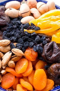 Üstten Görünüm Orta Asya kurutulmuş meyve ve fındık tipik bir mavi seramik tabak içinde. Kuru Kayısı, mango, incir, Kuru üzüm, ceviz, badem