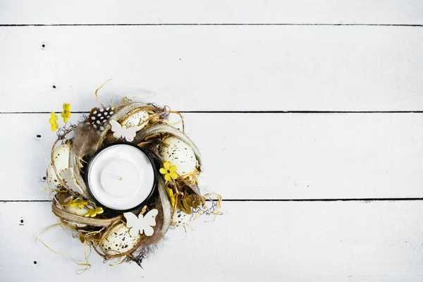 Ostern Frühling dekorative Komposition, handgefertigten Kranz mit Kerze im Inneren. Nahaufnahme Porträt auf weißem Holzgrund mit Platz für Text. — Stockfoto