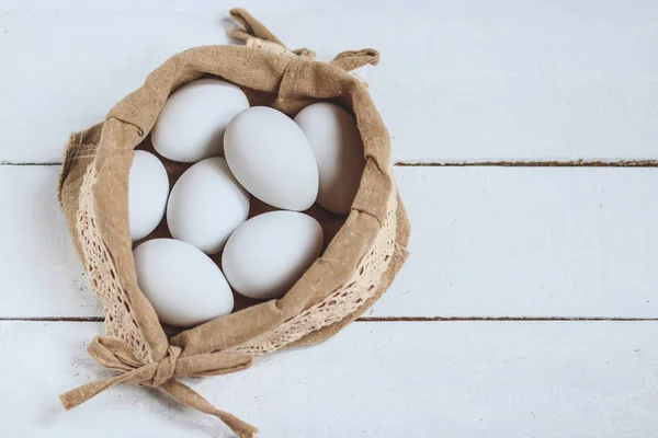 Concepto Pascua Huevos Pollo Blanco Saco Rústico Sobre Fondo Madera — Foto de Stock