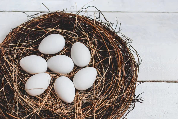 Ostereier im Nest auf rustikalem Holzgrund — Stockfoto