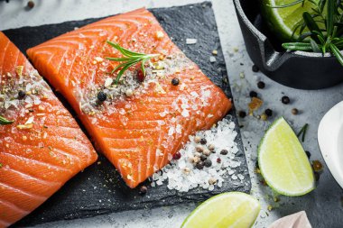 İki adet taze ot biberiye, baharat ve siyah arduvaz plaka üzerinde zeytin yağı ile Çiğ somon fileto