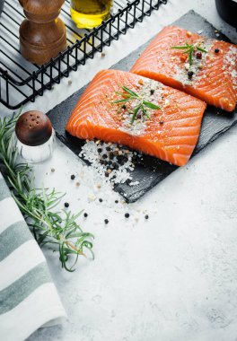 İki adet taze ot biberiye, baharat ve siyah arduvaz plaka üzerinde zeytin yağı ile Çiğ somon fileto