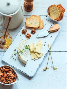 Peynir tabağı kraker, bal ve fındık ile servis. Camembert Beyaz ahşap beyaz doku arka plan üzerinde kurulu hizmet. Meze Tema. Üstten Görünüm alanı ile