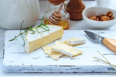 Peynir tabağı kraker, bal ve fındık ile servis. Camembert Beyaz ahşap beyaz doku arka plan üzerinde kurulu hizmet. Meze Tema.