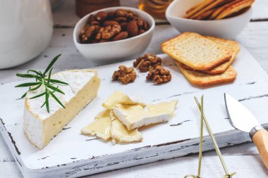 Peynir tabağı kraker, bal ve fındık ile servis. Camembert Beyaz ahşap beyaz doku arka plan üzerinde kurulu hizmet. Meze Tema.