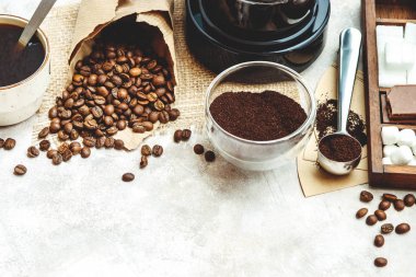 Çeşitli şeyler için kahve hazırlayın. Kavrulmuş fasulye, çekilmiş kahve, Kepçe, elektrikli kahve makinesi ve tatlılar ve açık renkli yemek için baharat çeşitleri.