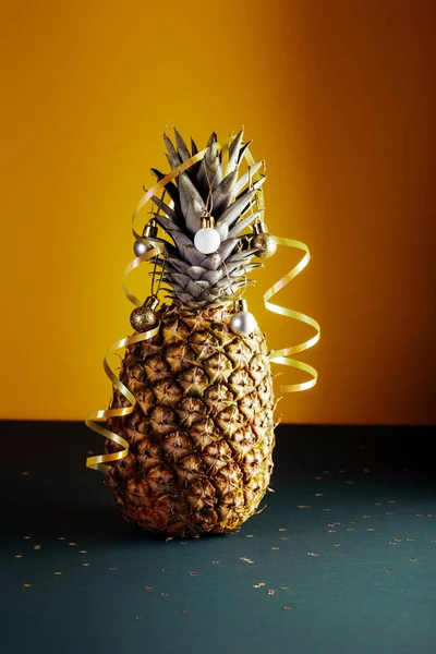 Ananas versierd met serpentijn en ballen, kerstvakantie en nieuwjaarsconcept Rechtenvrije Stockfoto's