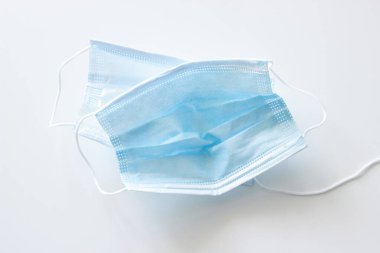 Beyaz arka planda iki adet mavi ve yırtık maske kullanılmış.
