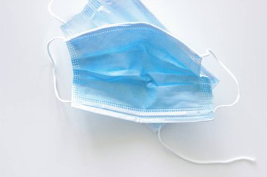 Beyaz arka planda iki adet mavi ve yırtık maske kullanılmış.