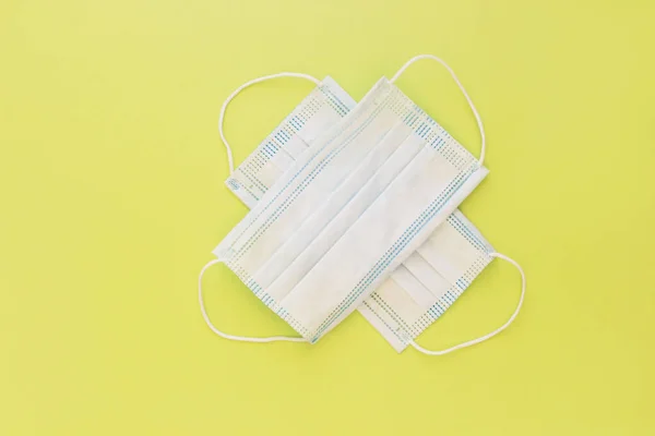 Duas Máscaras Brancas Médicas Usadas Fundo Amarelo Brilhante — Fotografia de Stock