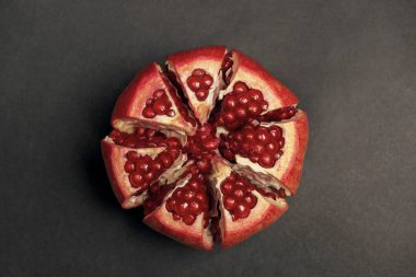 Siyah zemin üzerinde kırmızı sulu kabuklu nar.