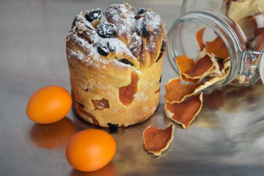 Kuru üzüm, kurutulmuş kayısı, şeker tozu ve mutfak masasında mandalina aromalı cam bir kavanoz ile süslenmiş Paskalya pastası gibi.