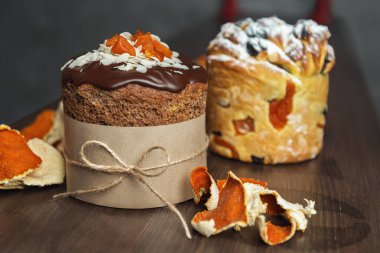 Ahşap masada farklı türde Paskalya pastaları ve mandalina tadı var.