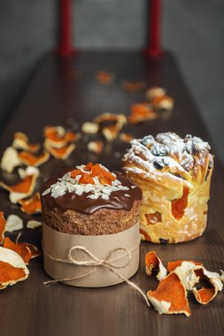 Ahşap masada farklı türde Paskalya pastaları ve mandalina tadı var.