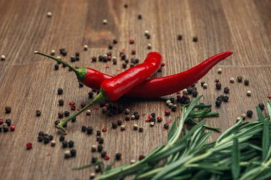 Kırmızı biberli kırmızı meyveler, biber ve ahşap zemin üzerinde biberiye.