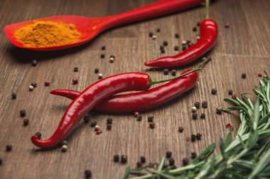 Kırmızı biberiyeli, biberiyeli, biberiyeli ve ahşap masadaki zerdeçal meyveleri.