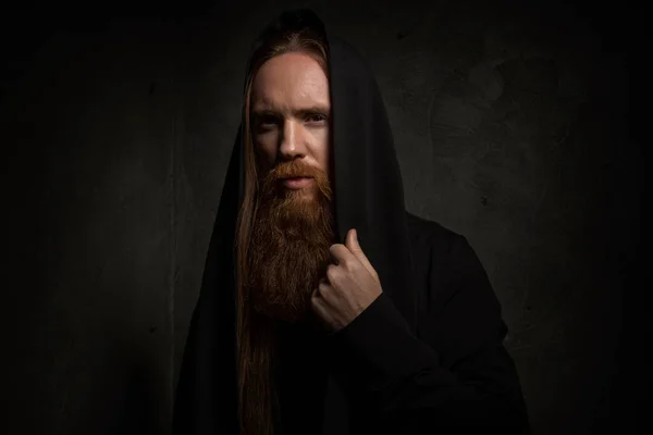 Мужчина Длинными Волосами Бородой Черном Капюшоне Темном Фоне — стоковое фото