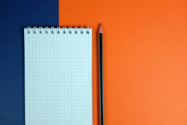 Parlak arkaplanda not defteri ve kalem