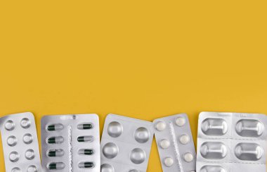 Sarı arka plan fotokopi alanındaki kabarcıklarda çeşitli haplar. İlaçlar