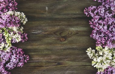 Eski ahşap arka planda leylak çiçekleri. Eflatun çiçeklerden oluşan bir kenar boşluğu kopyalar.