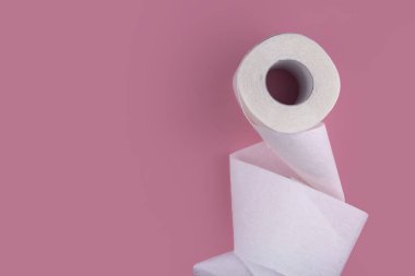 Pembe arka planda bir rulo beyaz tuvalet kağıdı. Tuvalet kağıdı eksikliği vardı..