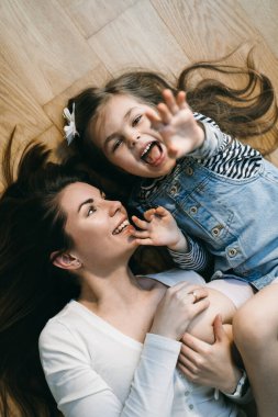 Anne yerde kızıyla oynuyor.