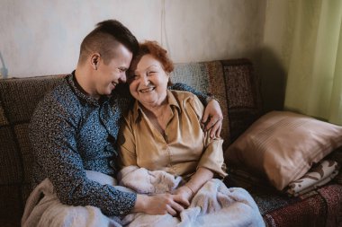Torunum kanepenin altında büyükannesiyle oturuyor ve ona sarılıyor, aile sevgisi