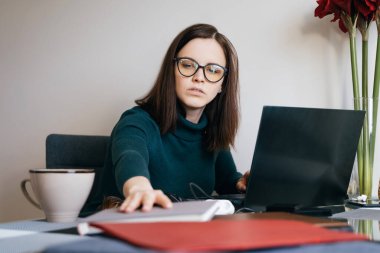 Kendini izole etme süresi boyunca evde çalışan konsantre bir kadın.