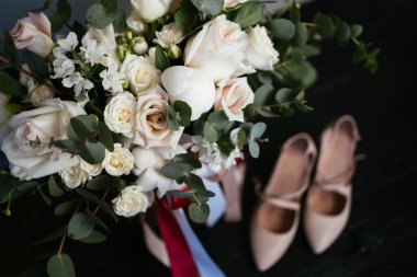 Düğün kırsal buketi ve siyah masada yüksek topuklu ayakkabılar.