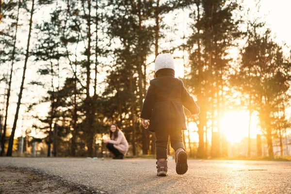 Gün batımının güzel ışığında küçük bir kız annesine doğru koşuyor.
