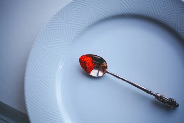 Beyaz arka planda kaşıkta kırmızı biber