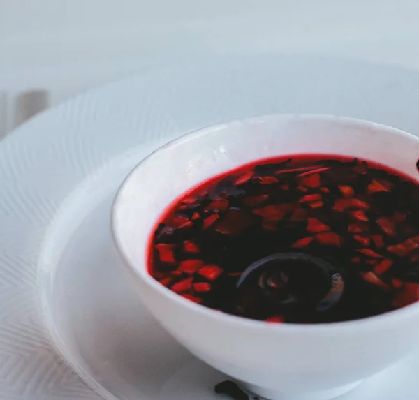 Hibiscus, beyaz arka planda beyaz cam bir fincanda, bir bardakta çay demledi.