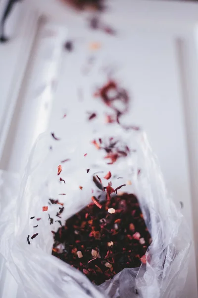 red hibiscus tea, loose, in a package on a white background