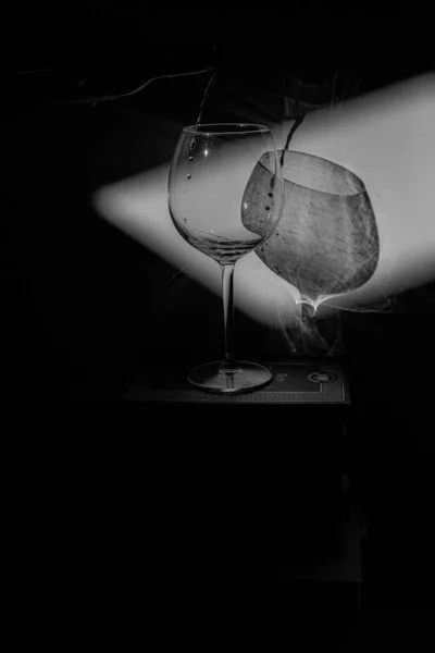 本や白黒写真の山の上のワインのグラスです — ストック写真