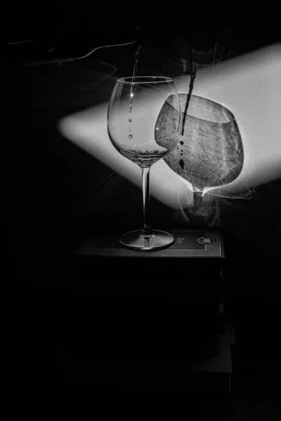 本や白黒写真の山の上のワインのグラスです — ストック写真