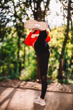 Atletik genç kız sokakta tekme atıyor.