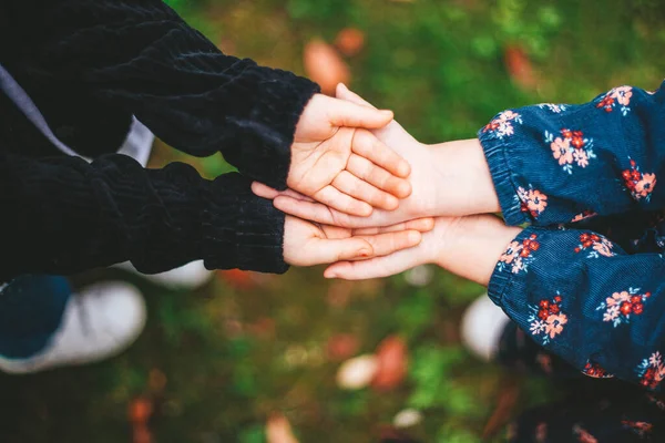 Çocukların elleri, kızların arkadaşlığı, yeşil park, bahar, güzel sıcak bir gün.