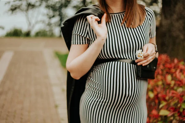 Hamilelik, 6 ay, hamile bir kız sıcak bir bahar gününde parkta duruyor, en güzel zaman.