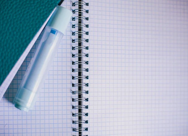 Açık kare bir defterin arka planında keçeli kalem, beyaz arkaplan, eğitim geçmişi olan mavi defter, evde kal.