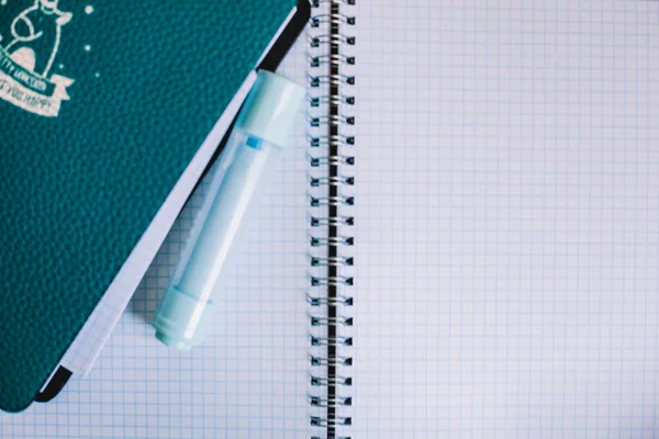 Açık kare bir defterin arka planında keçeli kalem, beyaz arkaplan, eğitim geçmişi olan mavi defter, evde kal.