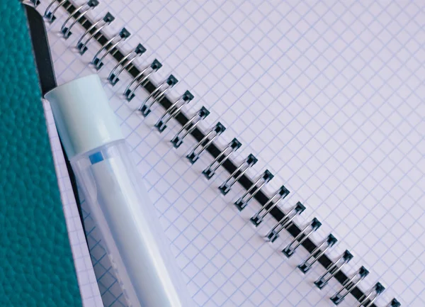 Açık kare bir defterin arka planında keçeli kalem, beyaz arkaplan, eğitim geçmişi olan mavi defter, evde kal.