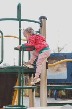 Çocuk parkında, doğal bir geçmişi olan sevimli bir çocuk. Sarı saçlı, at kuyruklu küçük bir kız. Güzellik, maharet, saç stili. Mutlu çocukluk kavramı.