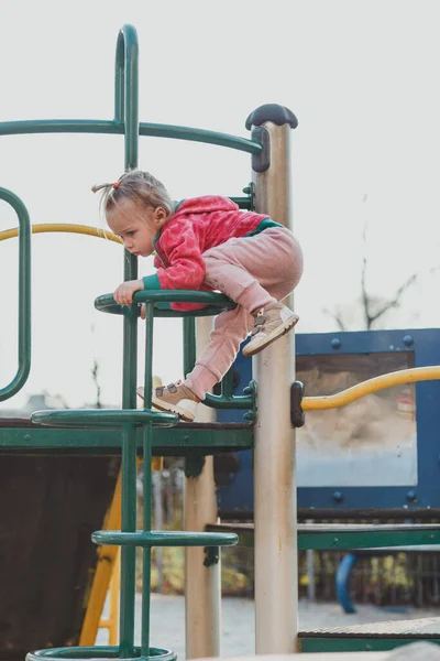 Çocuk parkında, doğal bir geçmişi olan sevimli bir çocuk. Sarı saçlı, at kuyruklu küçük bir kız. Güzellik, maharet, saç stili. Mutlu çocukluk kavramı.