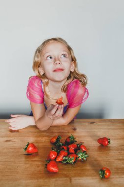 Çilek yiyen sevimli Avrupalı kız. Güzel, neşeli bir erkek arkadaş.