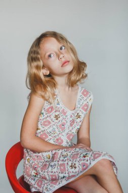 Avrupalı sarışın kız gri arka planda çilek yiyor. beyaz dişler.