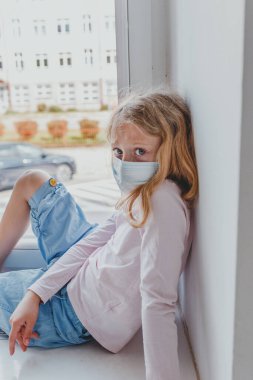 Sarışın Avrupalı kız karantinada maske takıyor.