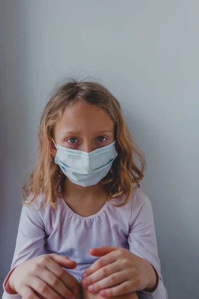 Karantinada maske takmış üzgün bir kız mavi gözlü. portr