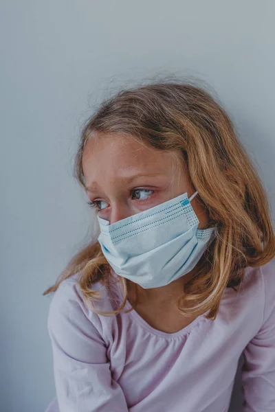 Karantinada maske takmış üzgün bir kız mavi gözlü. portr
